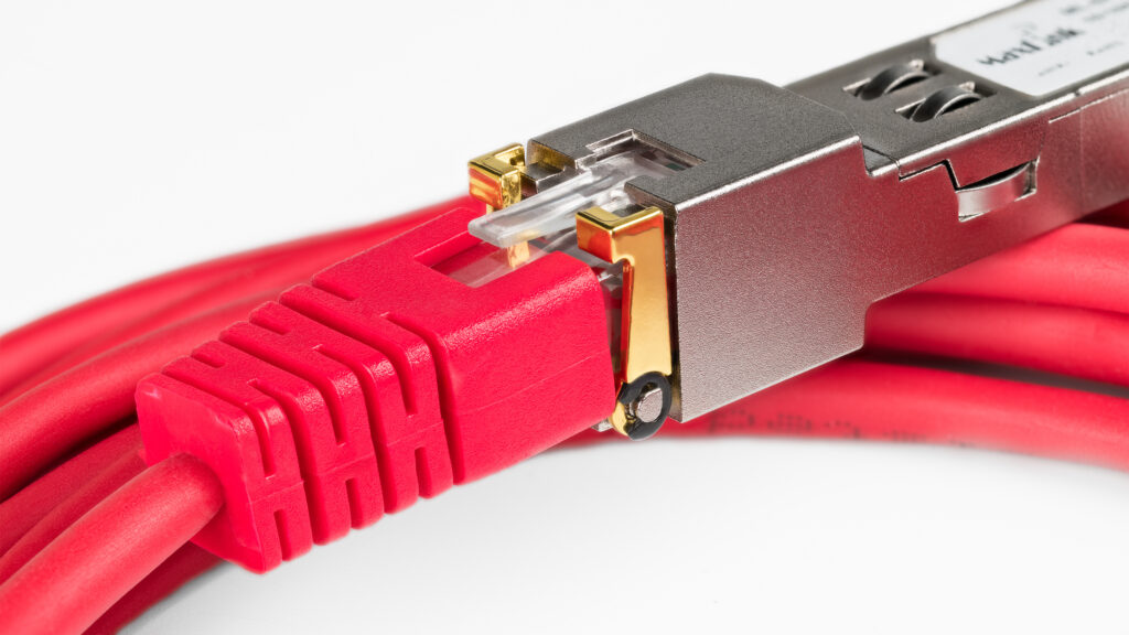 registered jack connector rj45 in network interface module detail on white background. closeup of standardized small form factor pluggable (sfp) transceiver and red ethernet twisted pair patch cables.